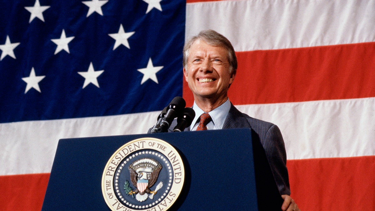 (Original Caption) 3/24/1979-Elk City, Oklahoma: President Jimmy Carter addressing a town meeting. American flag is hung in background.