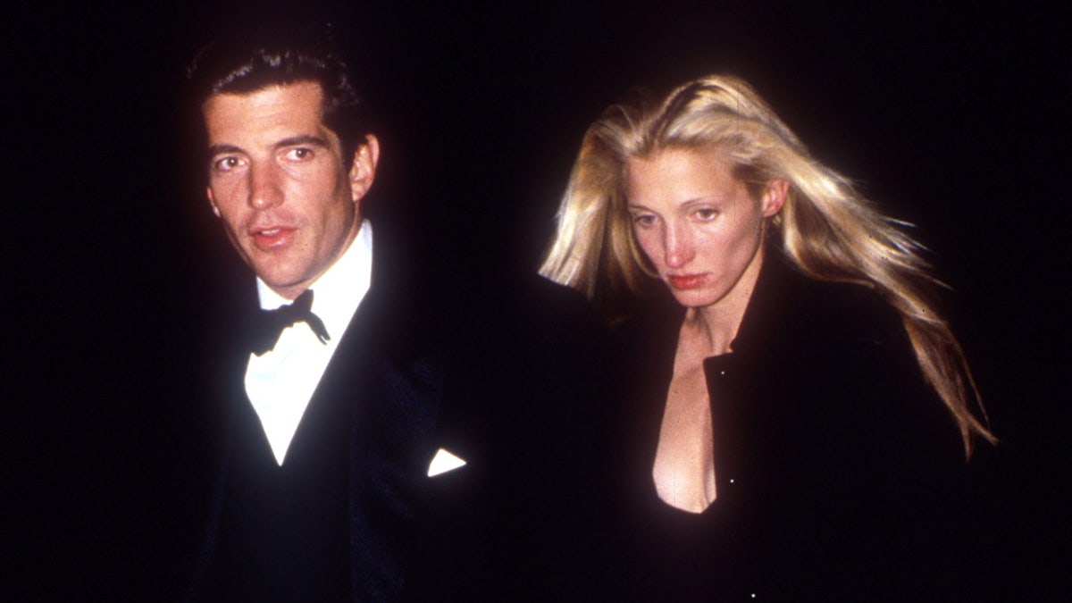 John F. Kennedy Jr. and Carolyn Bessette-Kennedy wearing black and walking outside at night