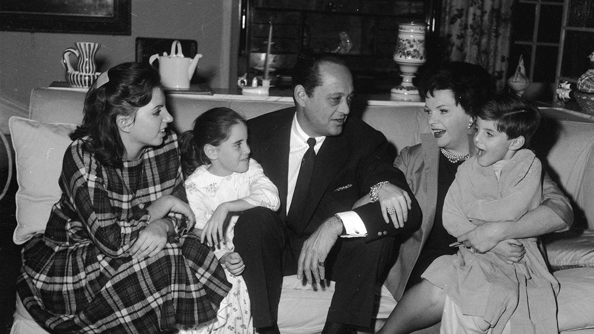 Judy Garland sitting pinch her hubby Sid Luft and her 3 children