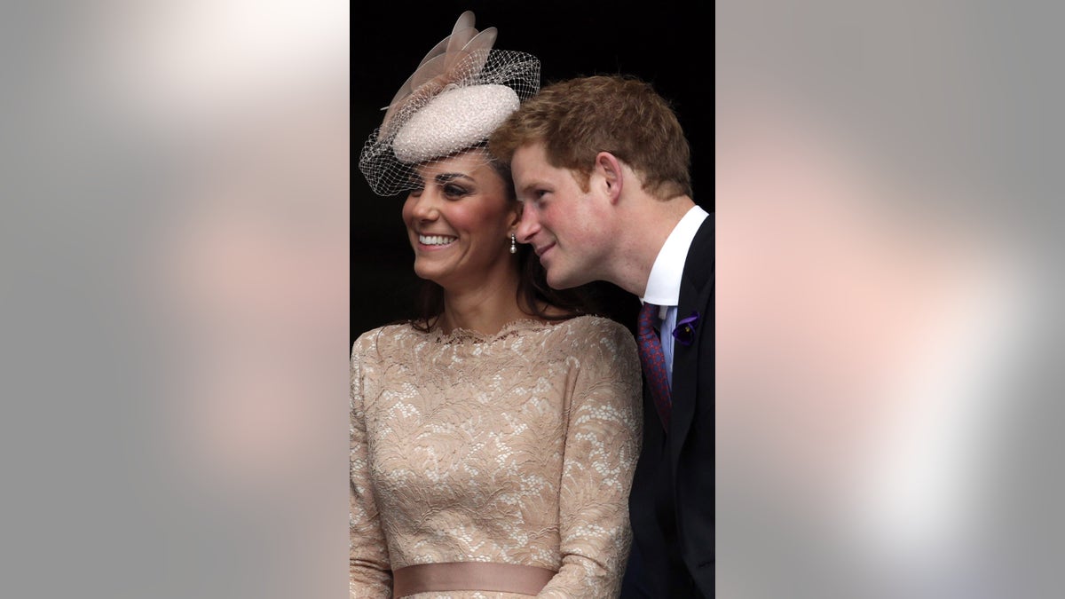 Prince Harry standing next to Kate Middleton as they both smile