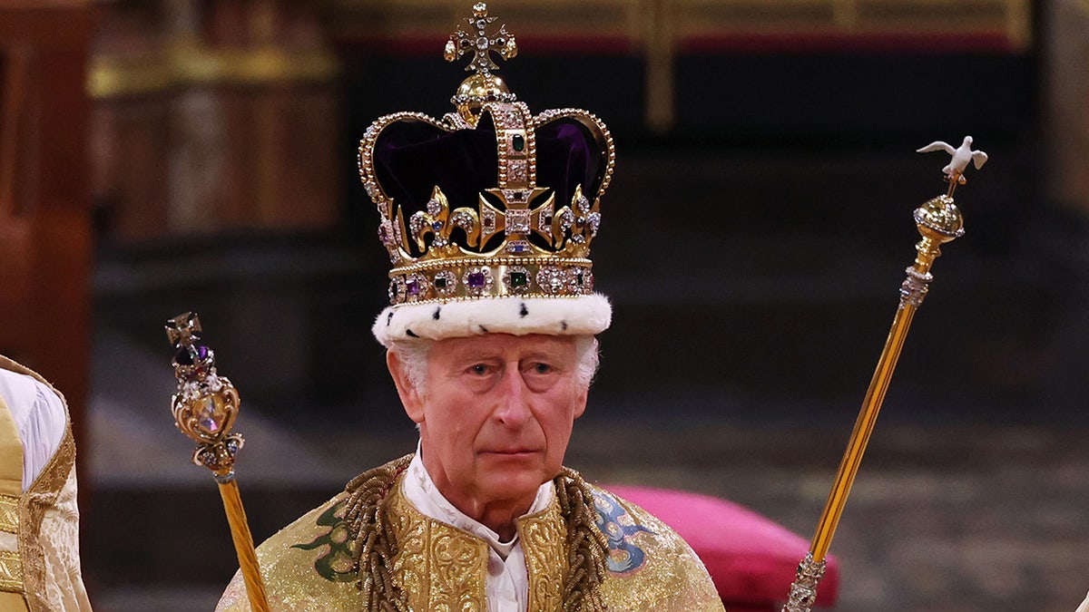 A close-up of King Charles wearing royal regalia and his crown