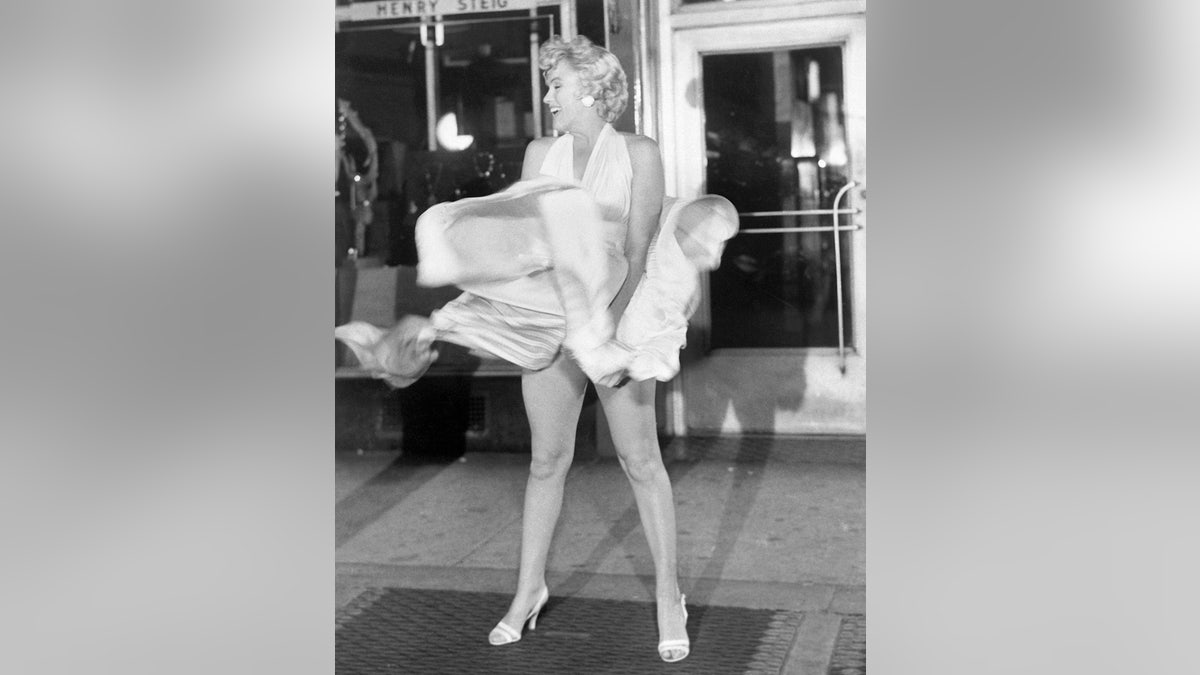Marilyn Monroe trying to hold down her flowing white dress
