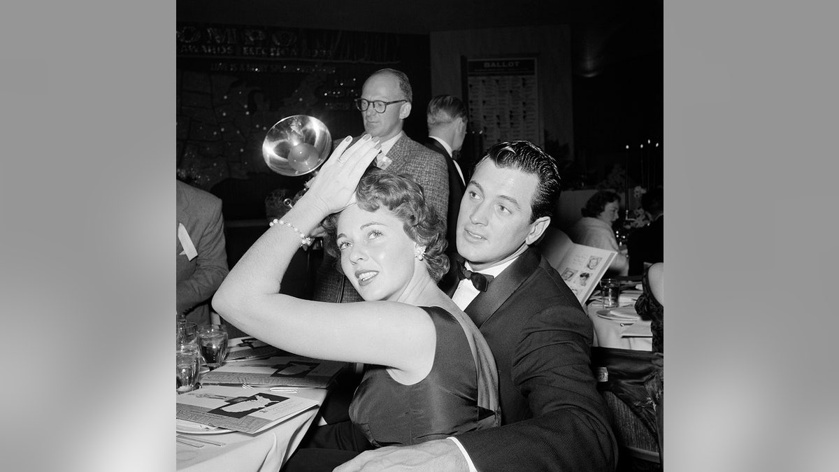 Rock Hudson with his arm around Phyllis Gates at a dinner party