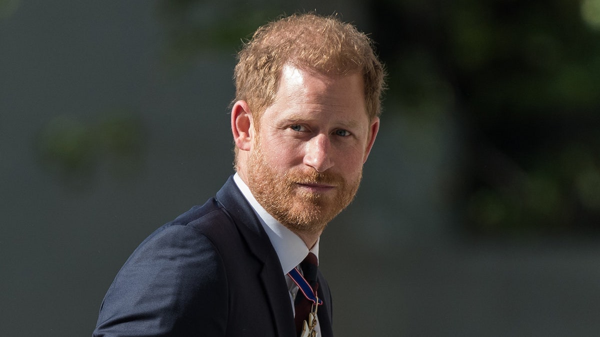 Prince Harry in a dark suit looking to the side