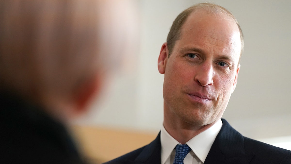 A close-up of Prince William listening