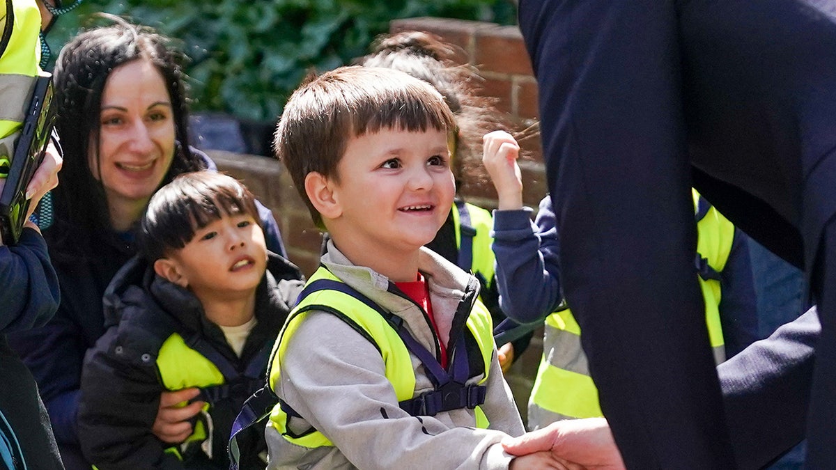 A small boy shakes Prince Williams hand
