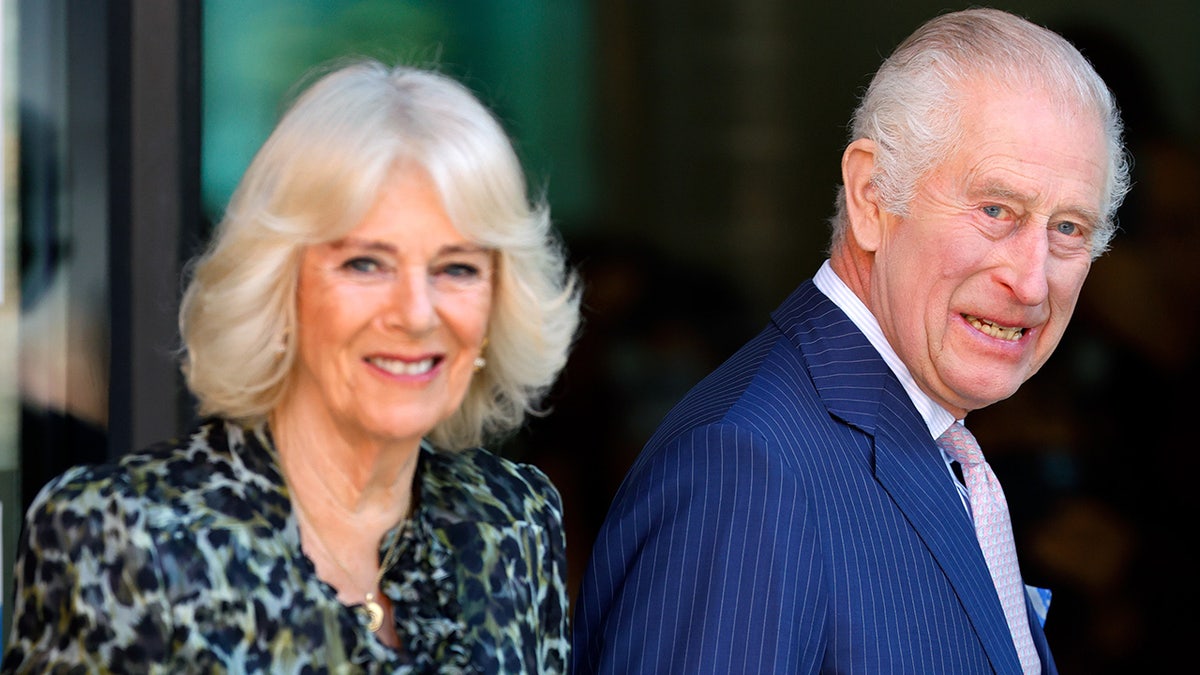 Queen Camilla and King Charles smiling as they walk together