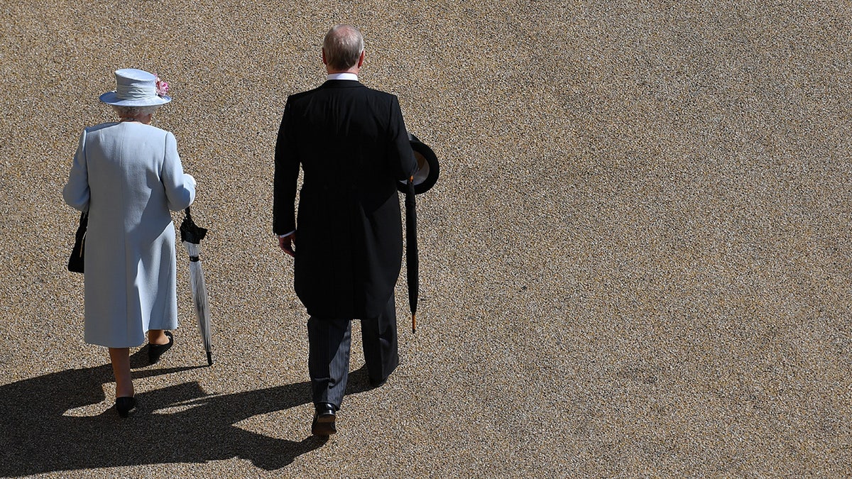 Queen Elizabeth and Prince Andrew walking together with their backs turned