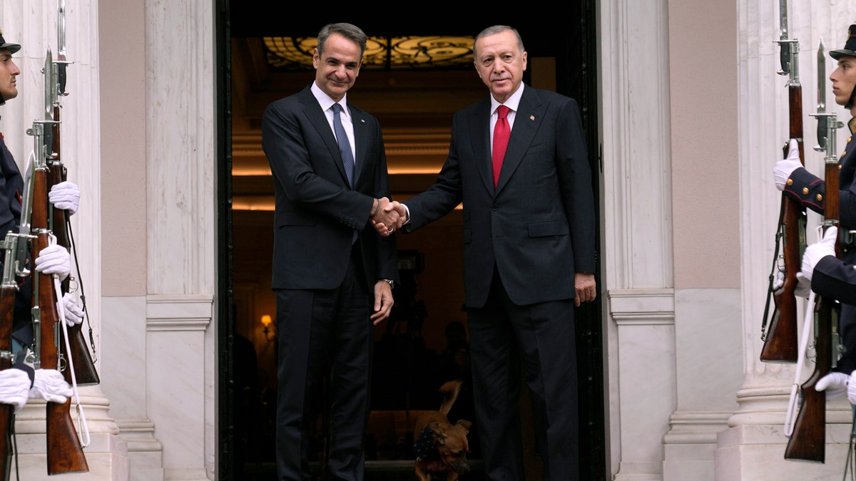 Greece's Prime Minister Kyriakos Mitsotakis, left, welcomes the Turkey's President Recep Tayyip Erdogan, right