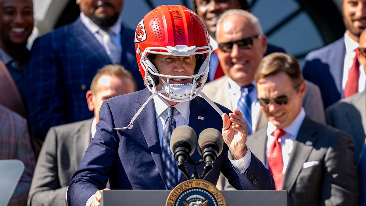 President Joe Biden wears a football helmet 
