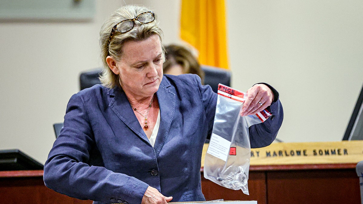 Kari Morrissey holds a bag of bullets in court