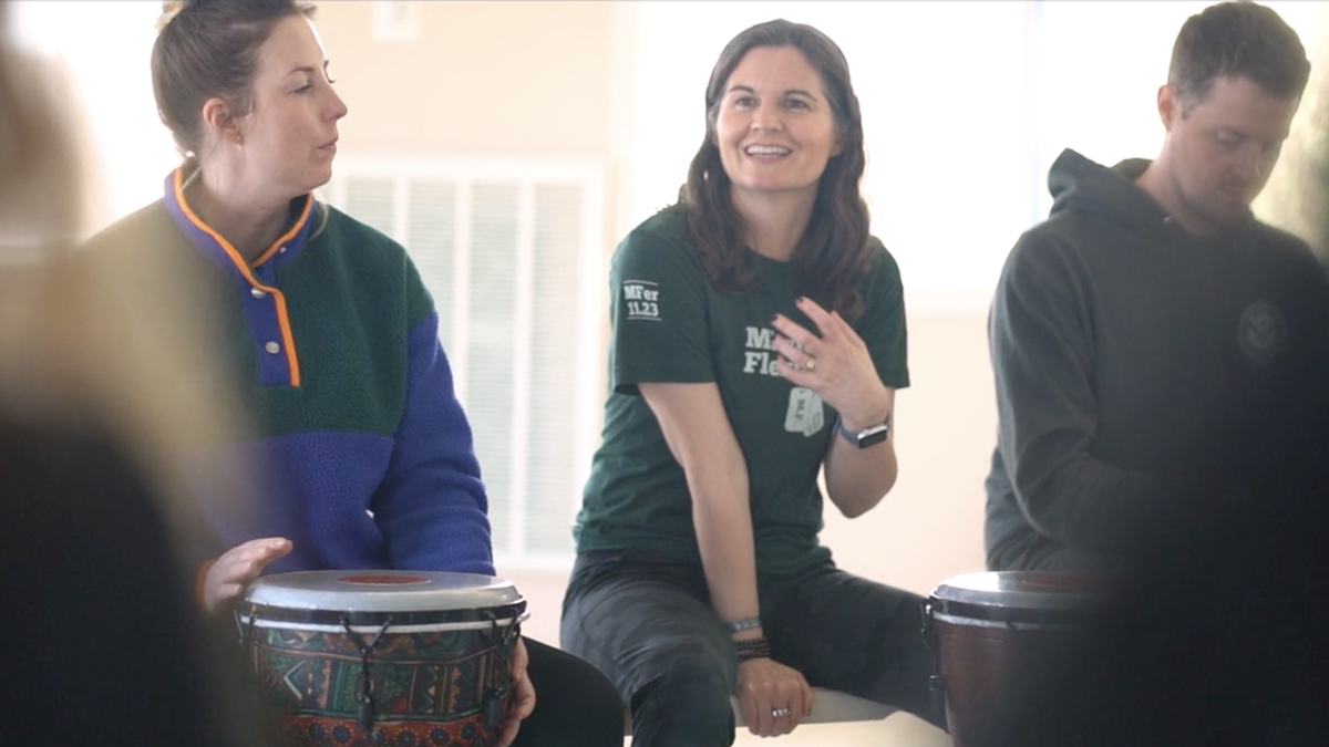 Lisa Jakub drumming with veterans at a retreat