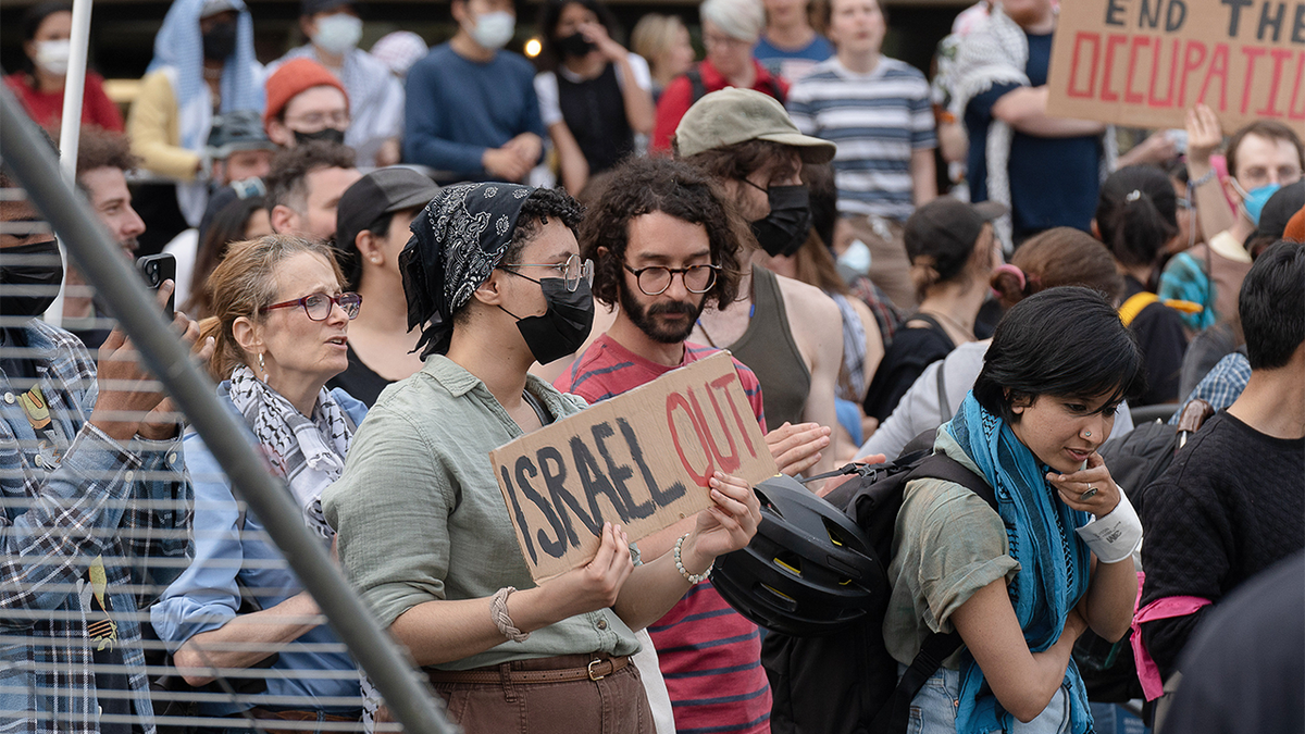 MIT میں مظاہرین نے نشانیاں پکڑی ہوئی ہیں۔
