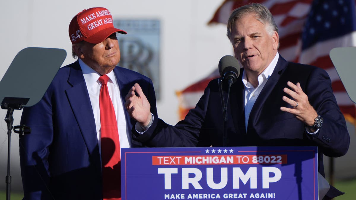 Former President Trump listens as Michigan Senate candidate and former Rep. Mike Rogers speaks at a campaign rally in Freeland, Michigan, on May 1, 2024.