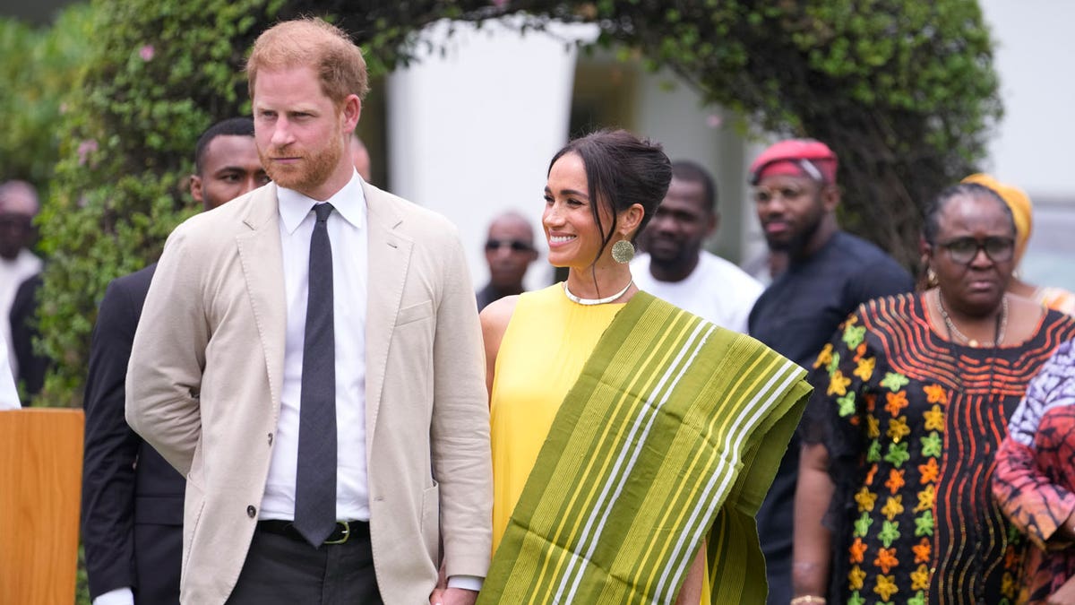 Prince Harry and Meghan hold hands upon arrival at the government house in Lagos, Nigeria, on May 12, 2024.
