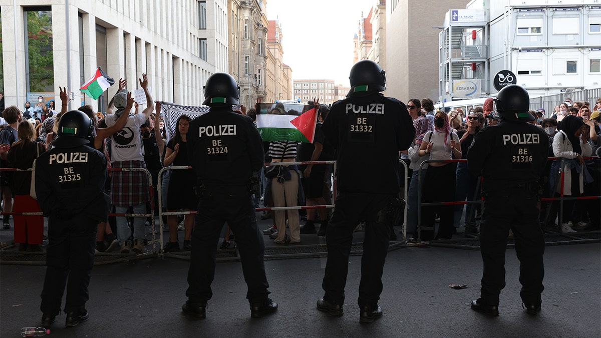 German police stand in front of anti-Israel protesters in front of Humboldt University in Berlin.
