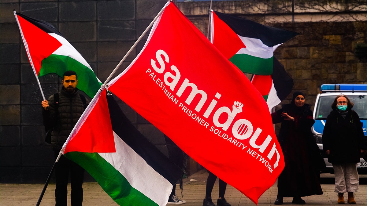 Protestors holding up the Samidoun flag.