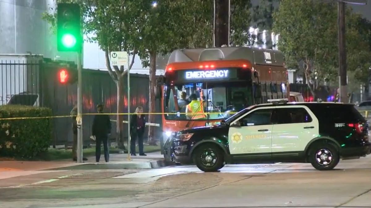Police tape surrounds a bus where a man was shot dead last week