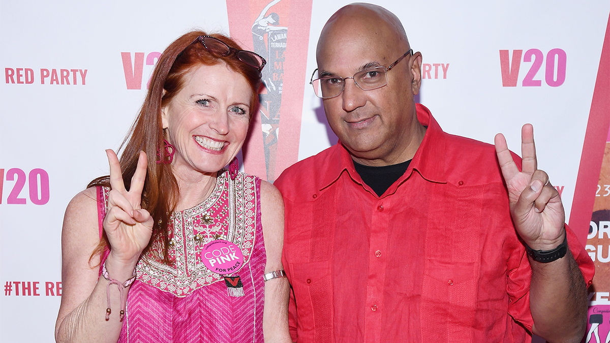 Jodie Evans and Neville Roy Singham make peace signs