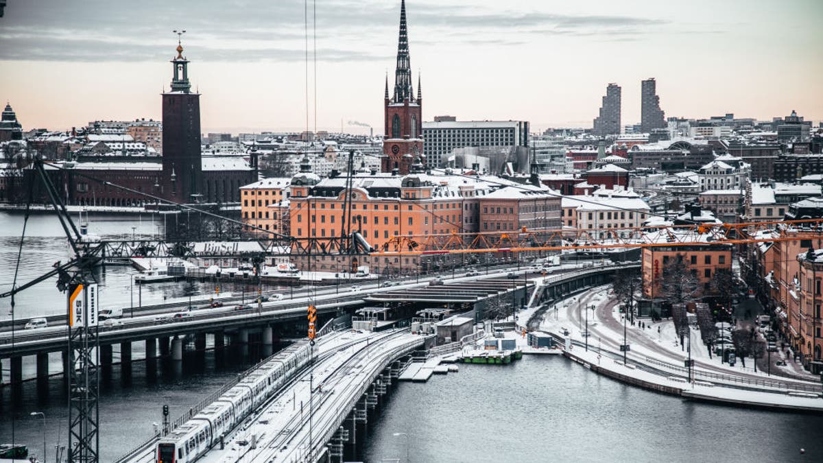 Aerial view of snowfall in Stockholm, Sweden over roads and buildings