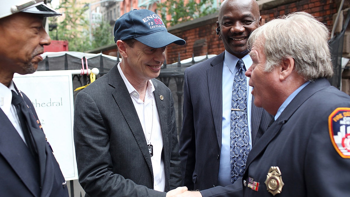 Steve Buscemi shaking hands with New York fire officials