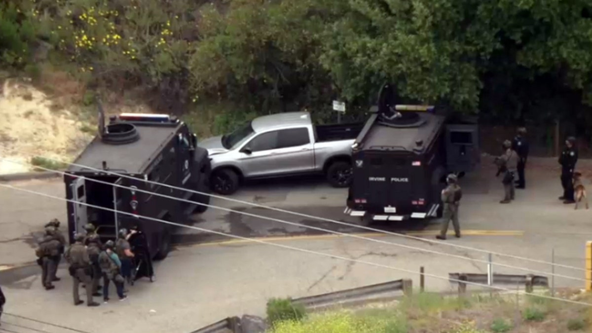 Silver pickup truck barricaded by police vehicles