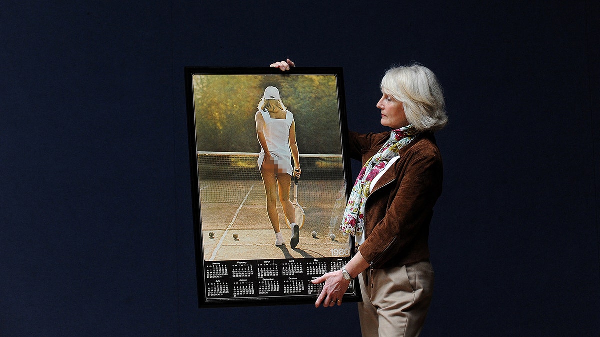 Fiona Walker holds up a image of herself from nan iconic image of nan Tennis Girl