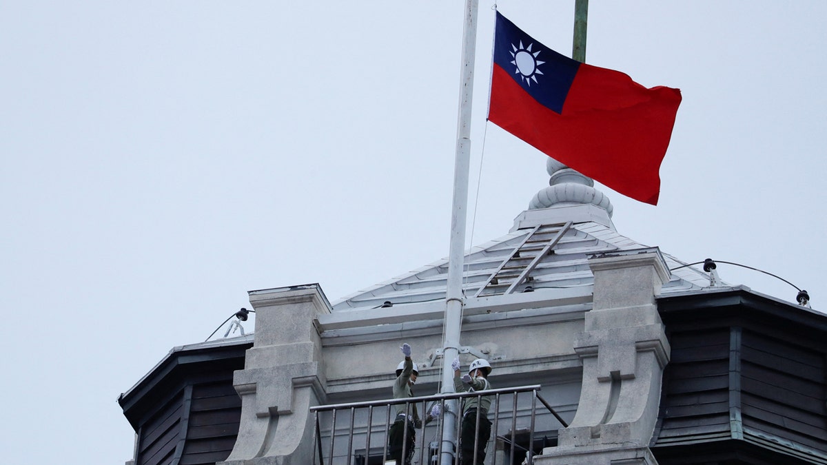 Honor guards raise a Taiwanese flag at the Presidential Palace ahead of the National Day celebration ceremony in Taipei, Taiwan.
