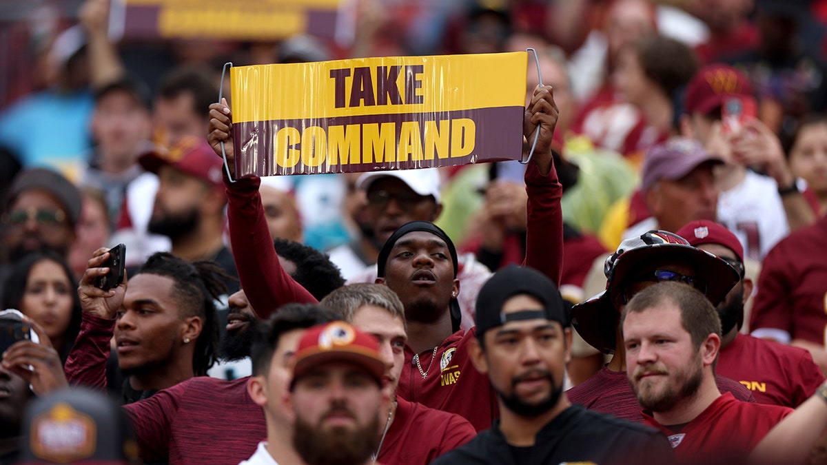 A Commanders fan with a 'Take Command' sign