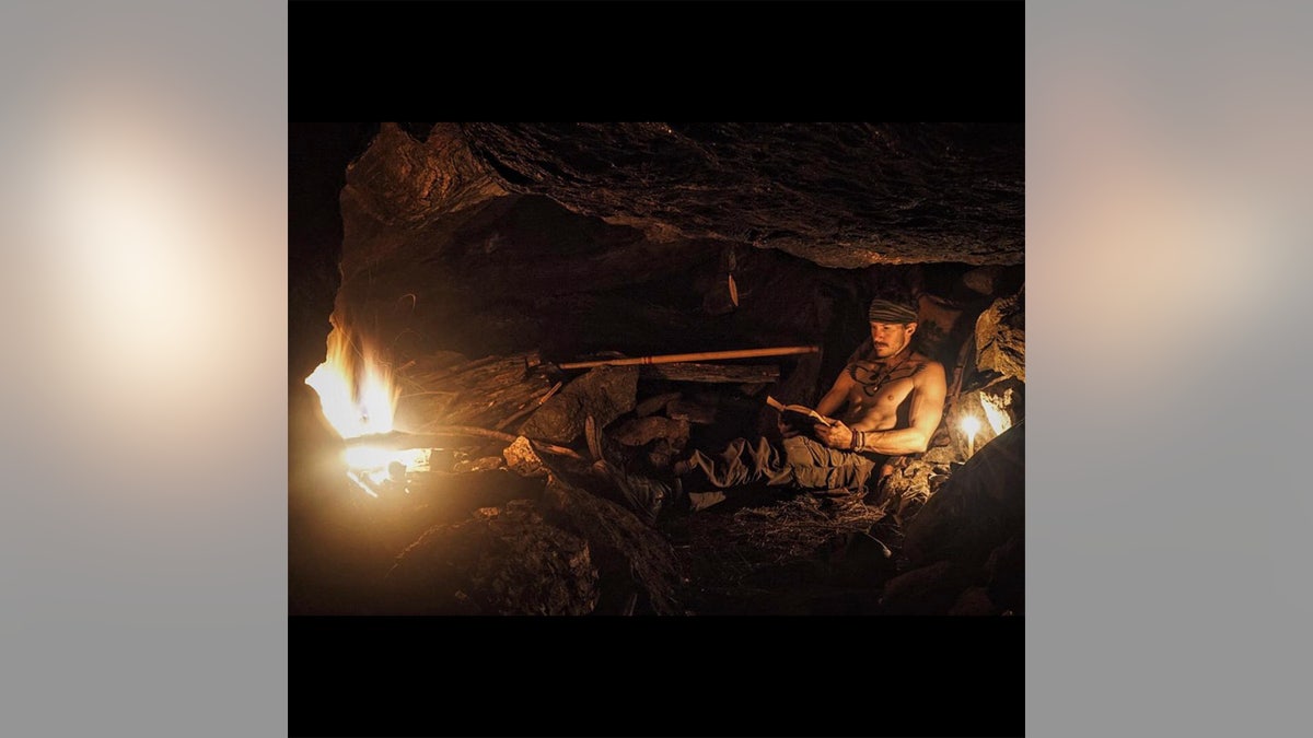 Justin Alexander Shetler inside a cave with fire