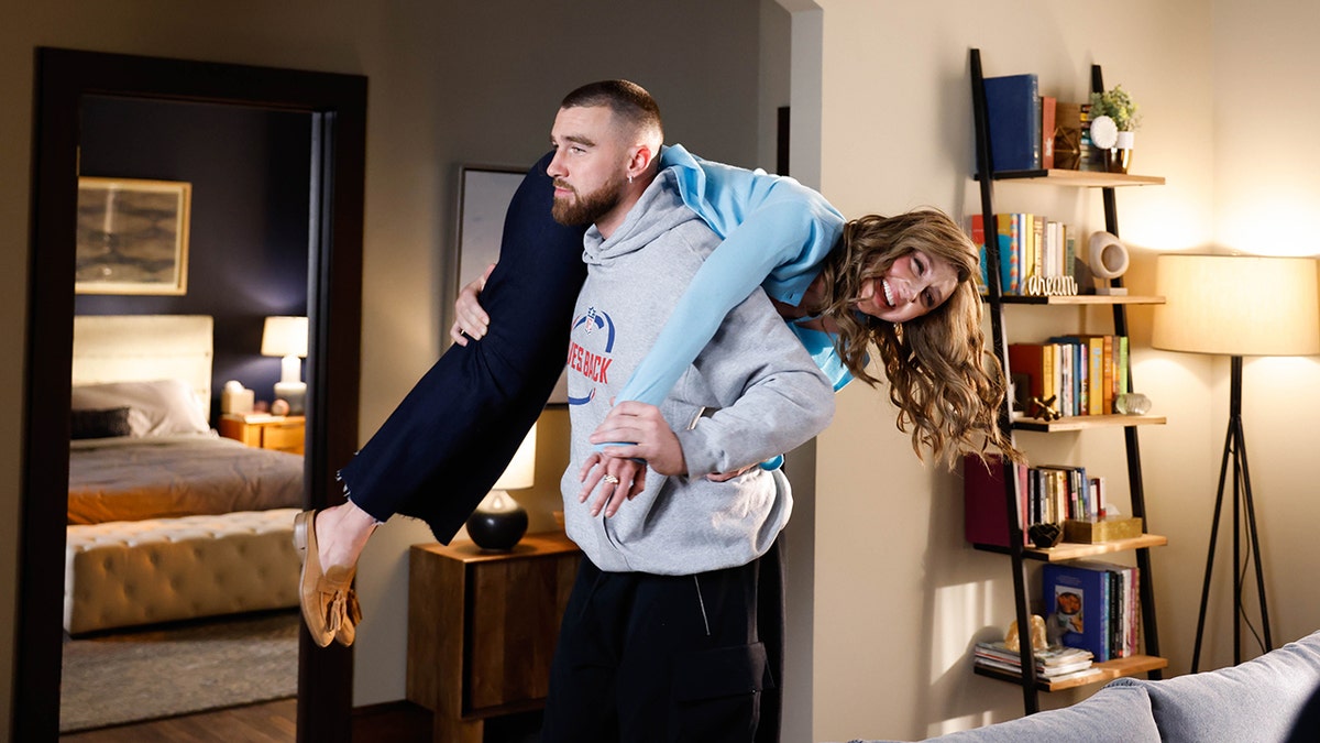 Travis Kelce lleva a Heidi Gardner al hombro en un sketch de SNL