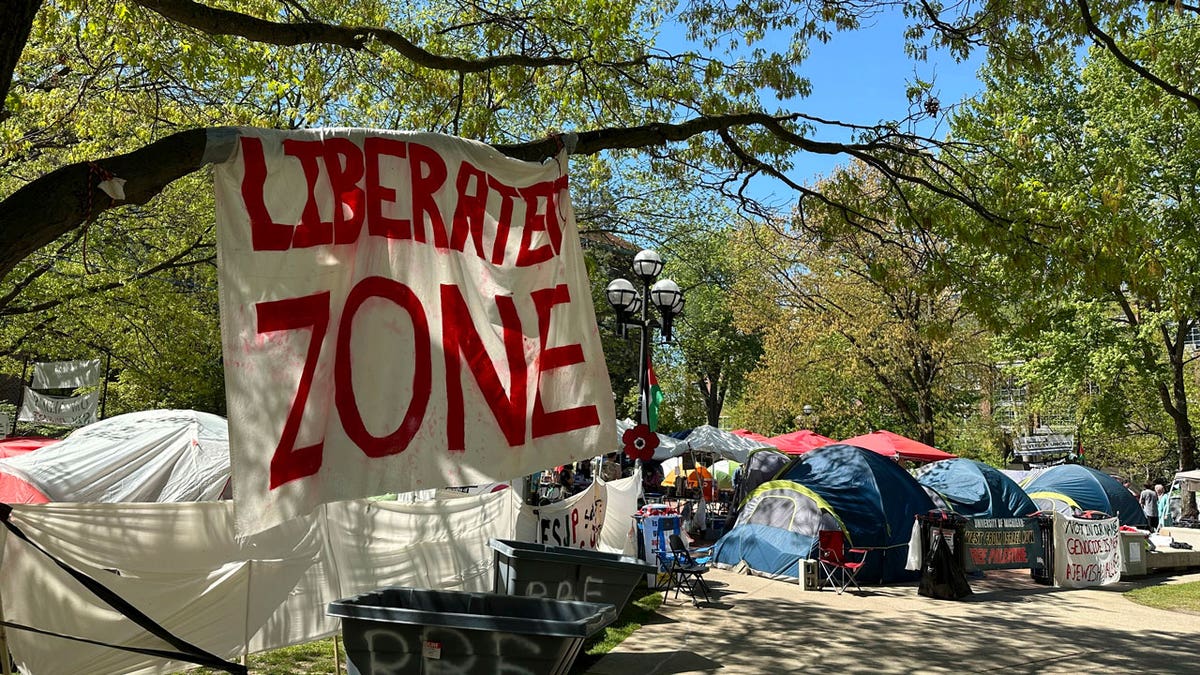 Tents and a sheet with the words "LIBERATED ZONE" are seen in an anti-Israel encampment at the University of Michigan in Ann Arbor