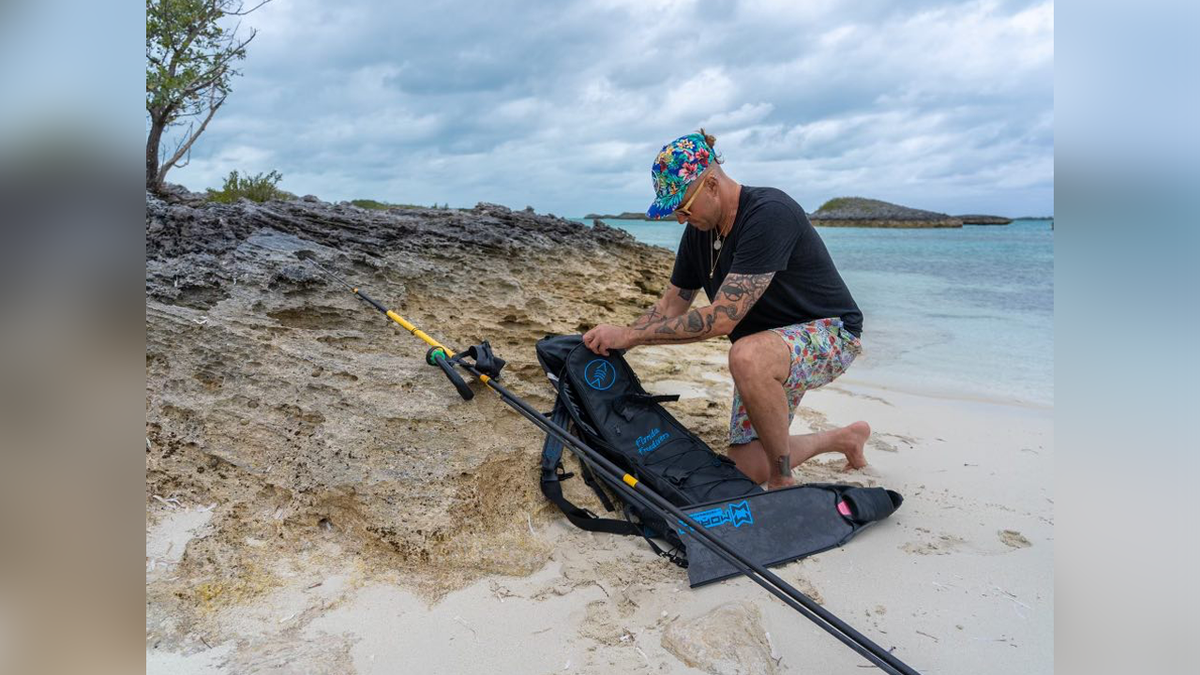 Virgil Price with diving equipment on a shore