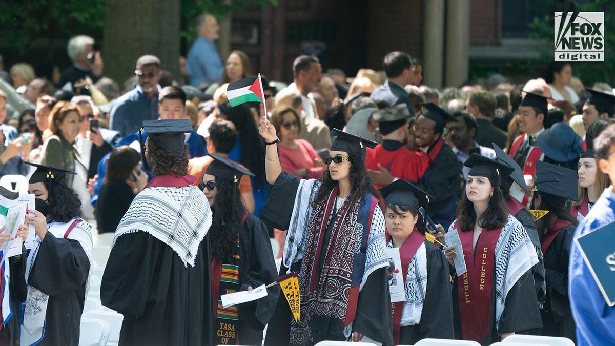 Graduados de Yale protestan contra la guerra Hamás-Israel, uno de ellos ondea una bandera de Palestina