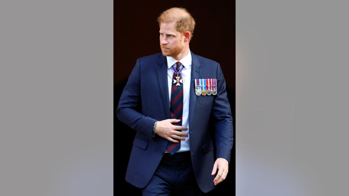 Prince Harry wearing a navy suit with medals