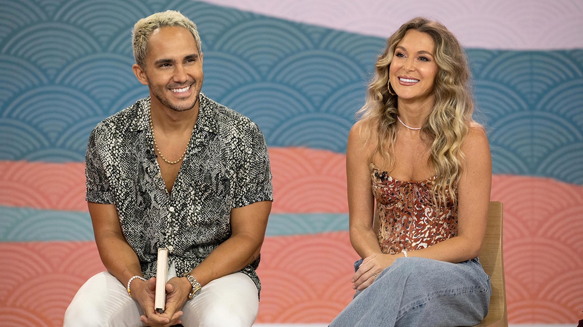Carlos in a snakeskin shirt and Alexa PenaVega in jeans and a tank top smile visiting TODAY