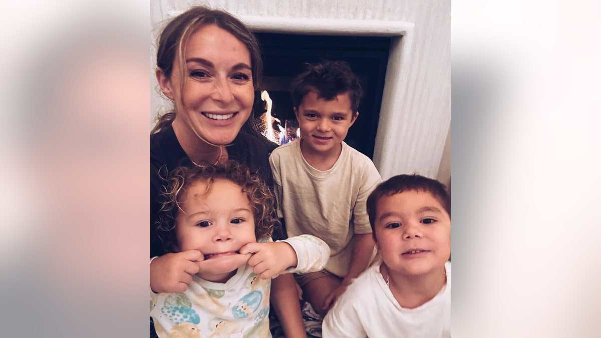 Alexa PenaVega and her two sons and one daughter smile for a photo