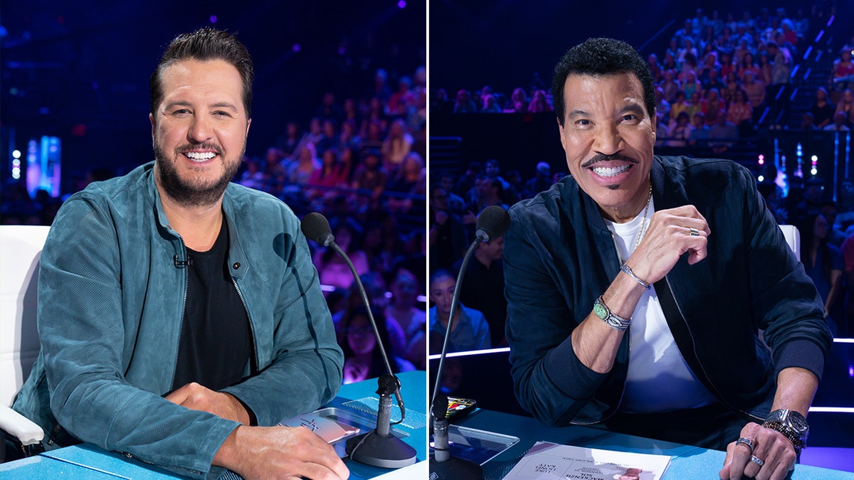 Luke Bryan detrás de la mesa de jueces de "American Idol" con una chaqueta azul partido Lionel Richie detrás del deak con una chaqueta azul marino