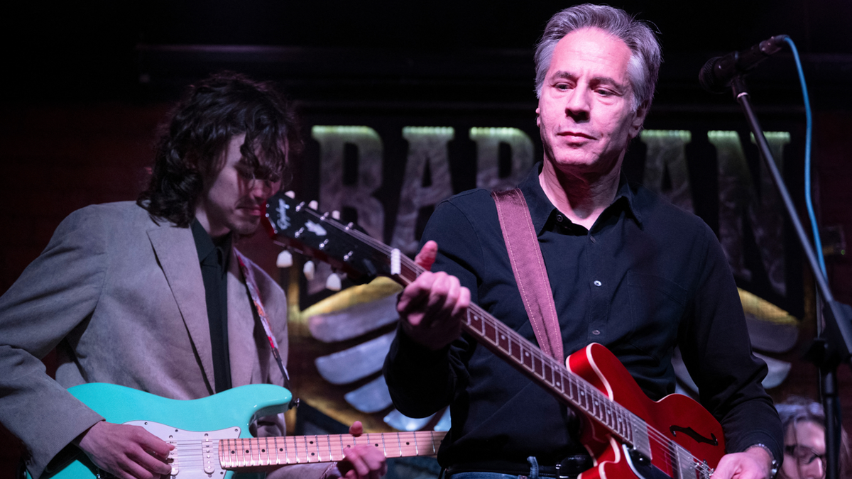 US Secretary of State Antony Blinken (R) performs "Rockin' in the Free World" with members of The 1999 band at the Barman Dictat bar in Kyiv on May 14, 2024.