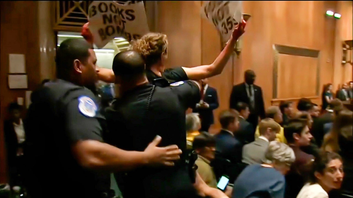Police carry an anti-Israel agitator out of Congress hearing