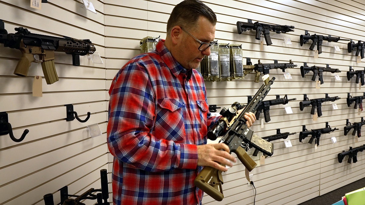 Man holds AR-15 in gun store