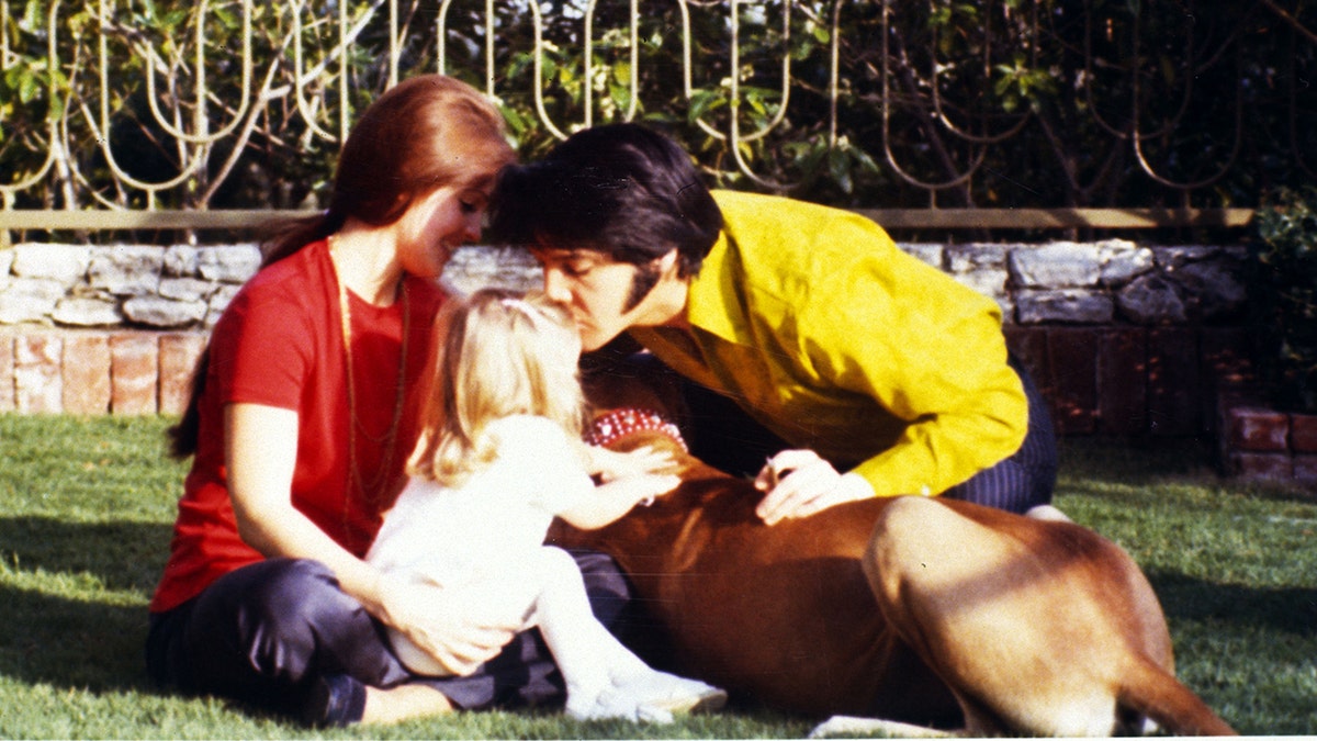 Priscilla y Elvis Presley con su hija y un perro