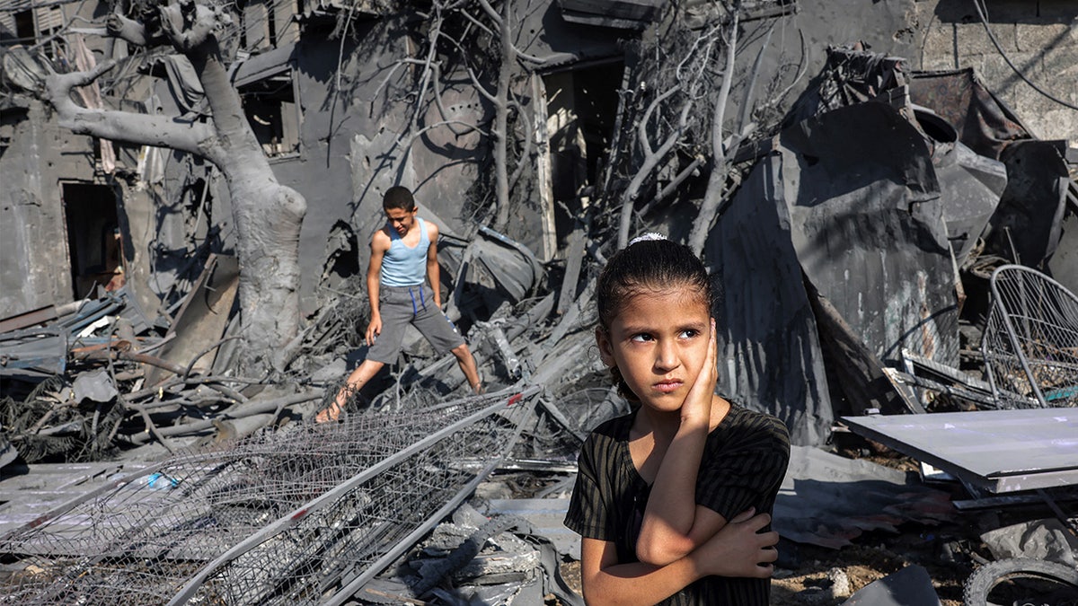 Children standing in front of rubble in Gaza