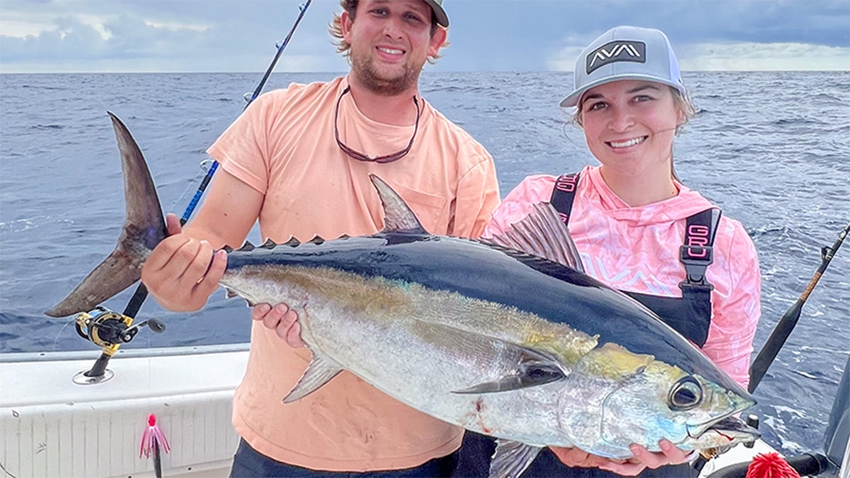woman and man holding large fish