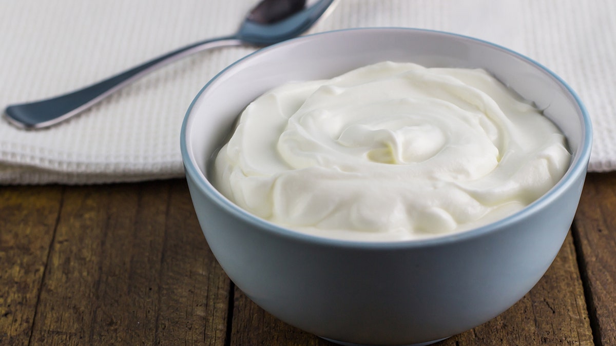 greek yogurt in bowl, spoon lying beside it