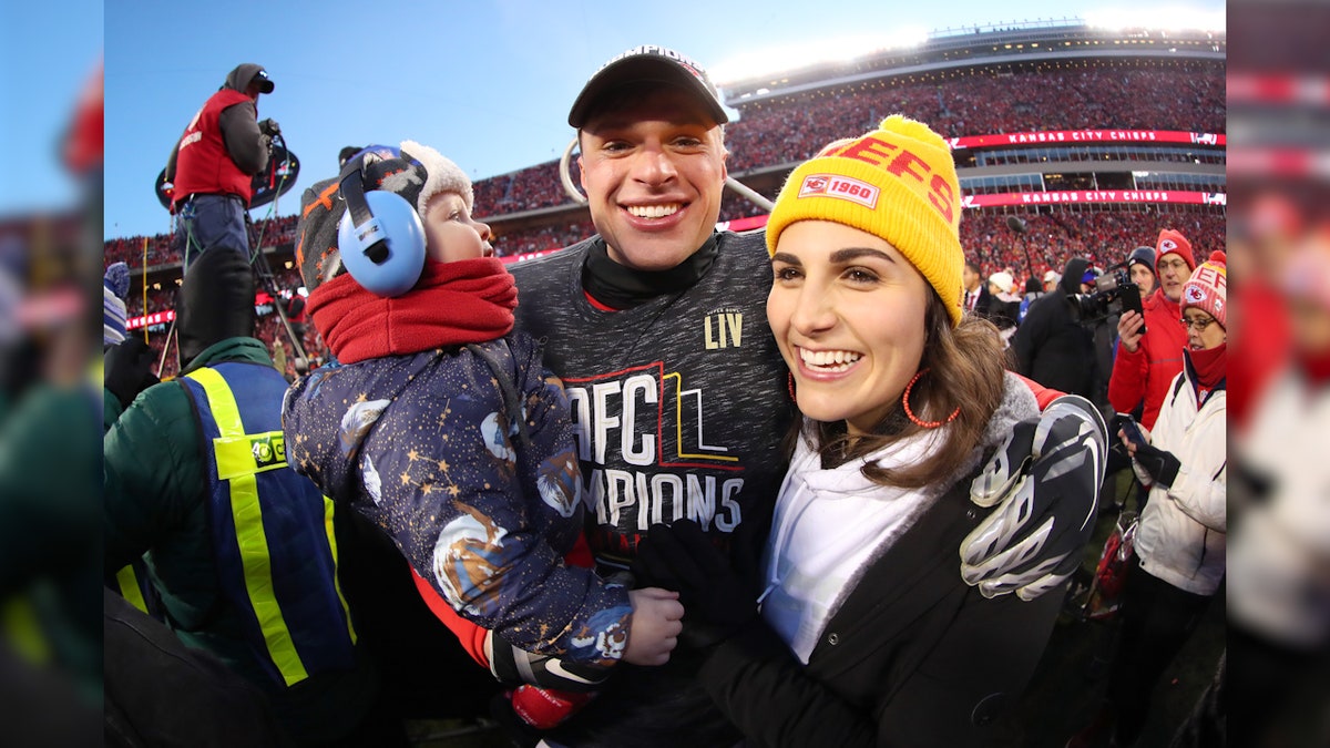 Harrison Butker sostiene a su hijo junto a su esposa Isabelle Butker