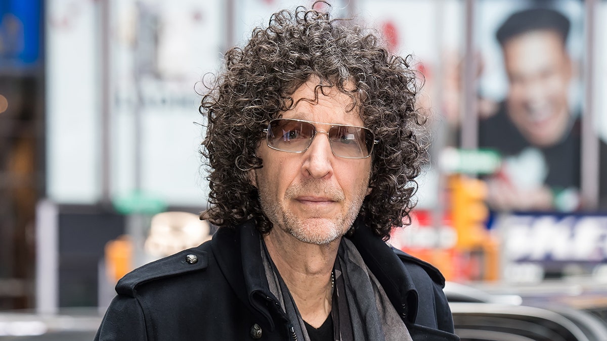 Howard Stern looks serious on the streets of New York in a black jacket and grey tinted sunglasses