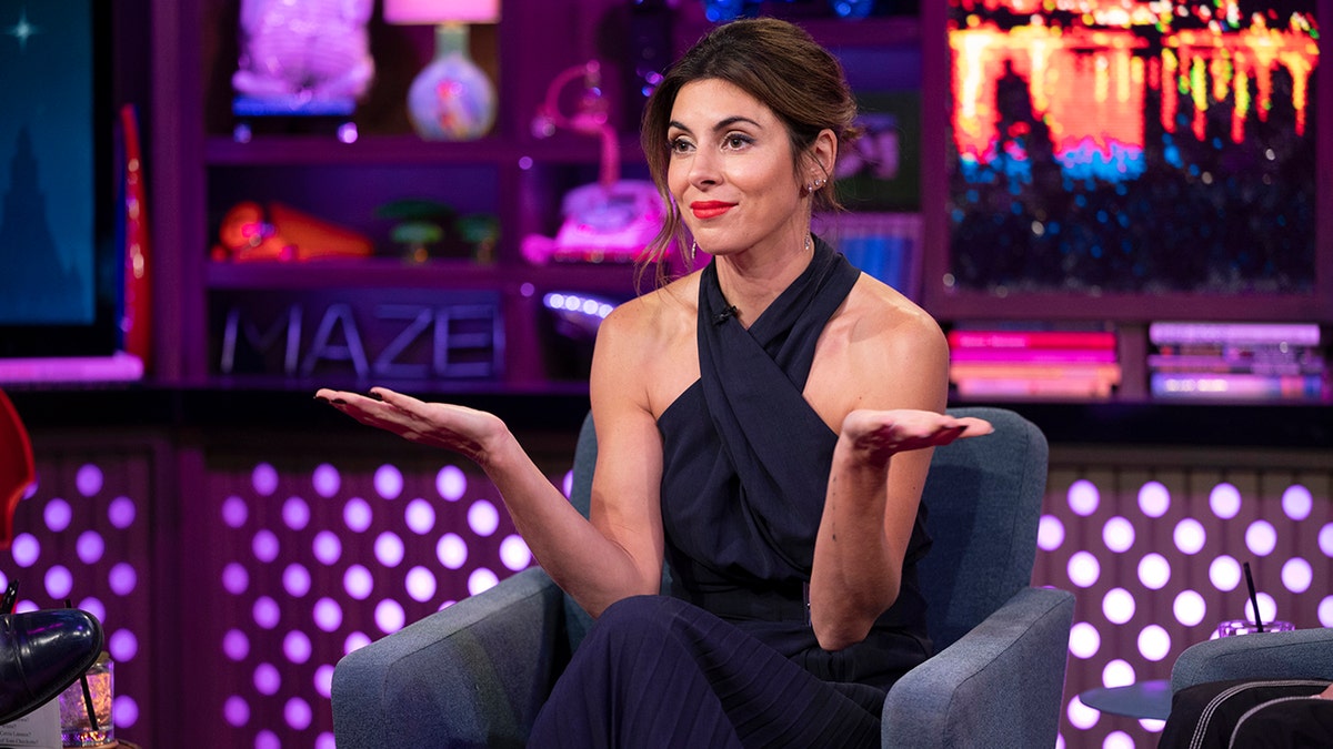 Jamie-Lynn Sigler puts her hands up to her side and shrugs in a black top