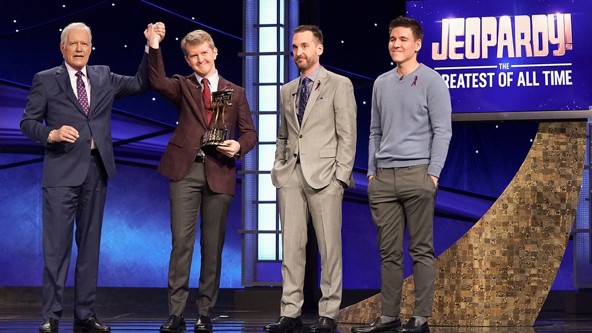 Ken Jennings holding the Greatest of All Time trophy after he won