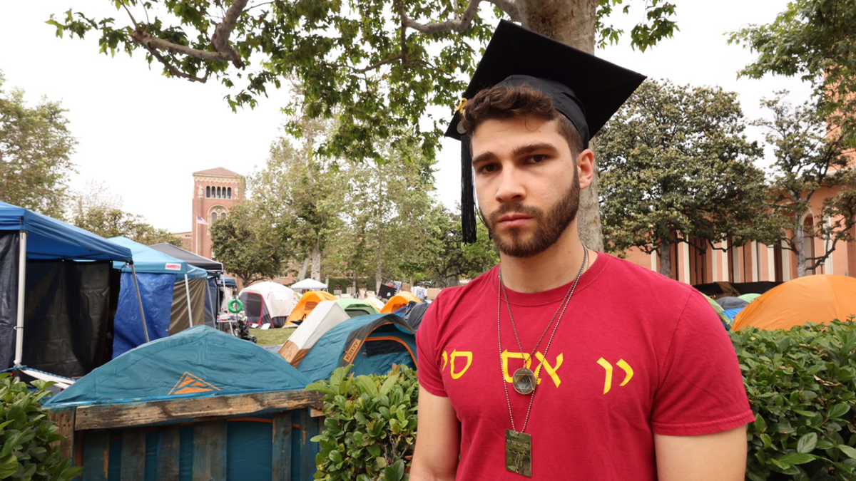 Mark Rayant, a USC student, stands next to encampment